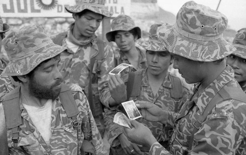 Army men look at photographs, Chajul, 1982