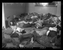 Jail cell filled with sleeping men arrested for drunkenness on Christmas Day in Los Angeles, Calif., 1950