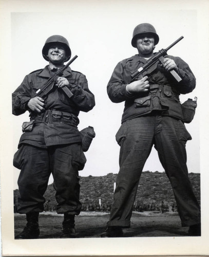 Two trainees pose with grease guns at Fort Ord