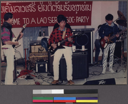 Three boys playing guitars at a Lao Seri Association party