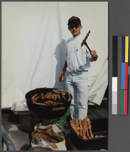 Man cooking Thai steaks at Fourth of July food festival, San Francisco, California