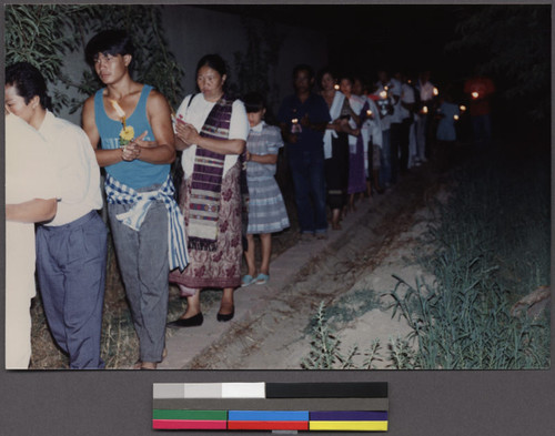 People holding candles in an outdoor procession for a Buddhist ceremony, Ceres, California