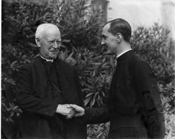 Handshake between Father Richard Gleeson, S.J., and Father Hugh C. Duce, S.J