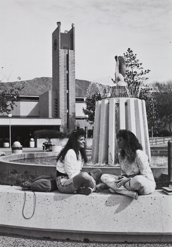 Students sitting at owl fountain, Citrus College, 1970s