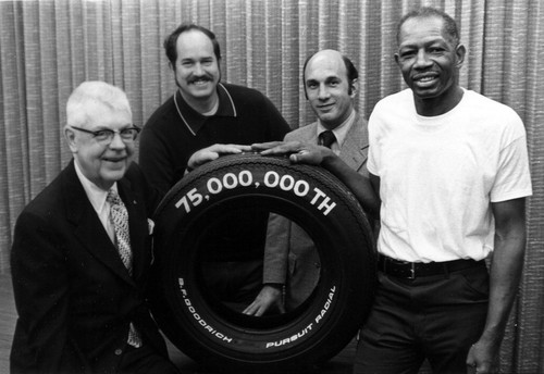 James Bristow and three other men displaying the 75,000,000th tire