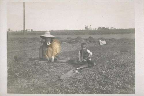 [Japanese mother and son working in a field.]