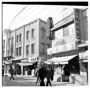 Men walking past a musical instrument shop, South Korea 1956-59