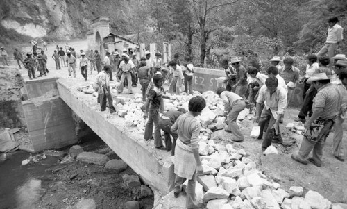 Civilians helping clean a crumbling bridge, Chichicastenango, 1982