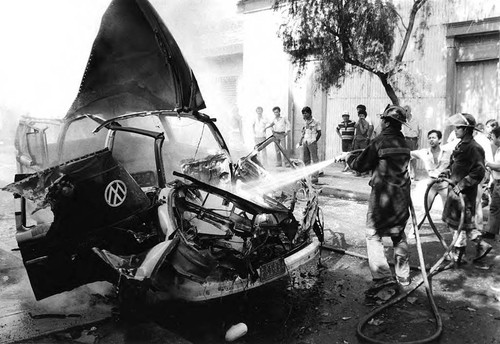 Firefighters extinguishing a car fire, San Salvador, 1982