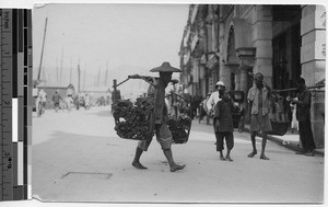 Street scene with people carrying bundles, Hong Kong, China, ca.1920