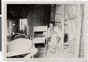 Dilgaasaa's son smoking a water pipe in the house, Guduru Gute, Ethiopia, ca.1952-1953