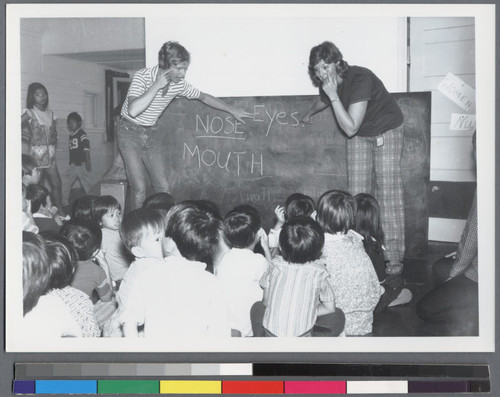 Children sitting in front of blackboard