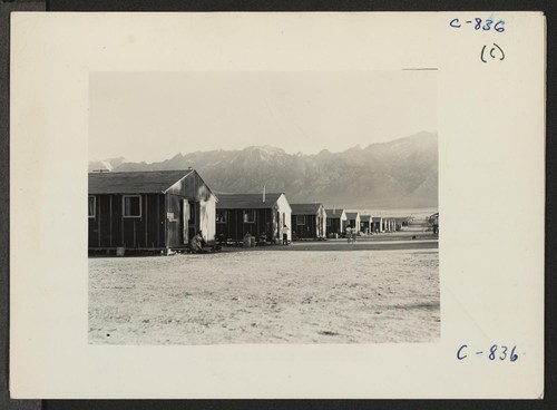 Manzanar, Calif.--Street at this War Relocation Authority center on a summer evening, showing the barrack apartments. Photographer: Lange, Dorothea Manzanar, California