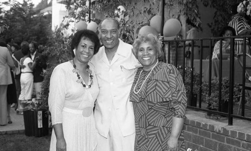 Jessie Mae Beavers, Le Roy Beavers, Jr. and Toni Carter posing at a champagne buffet, Los Angeles, 1985