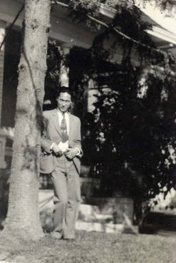 Photo of a Chinese American man posed in the front yard of a house