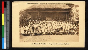 Newly-baptized people assembled before a thatch-roofed building, Cameroon, ca.1920-1940