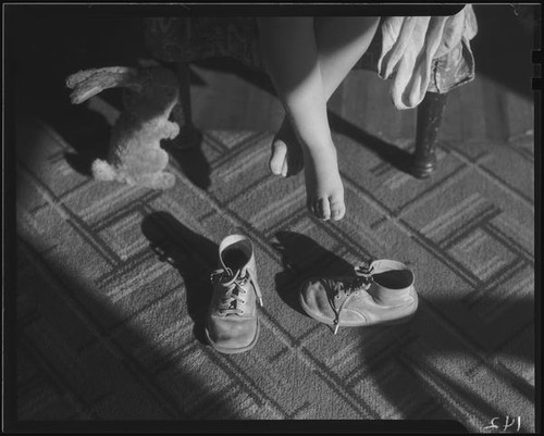 Child's feet above empty shoes, Los Angeles, circa 1935