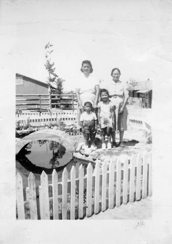 Nakano family members Standing in a Japanese garden at Granada Relocation Center