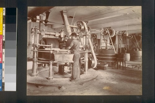 [Factory worker operating machinery.]