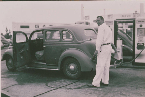 Gas station attendant filling up an automobile at a Sunset Blvd. service station in Pacific Palisades