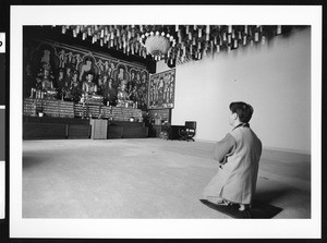 Monk kneeling at shrine, Los Angeles, 1999