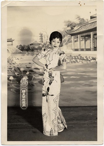 Actress in sequinned cheongsam strikes a coquettish pose /