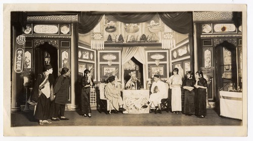 Two monks talk with a high buddhist lama in the temple confines while 4 ladies and 2 men look on /