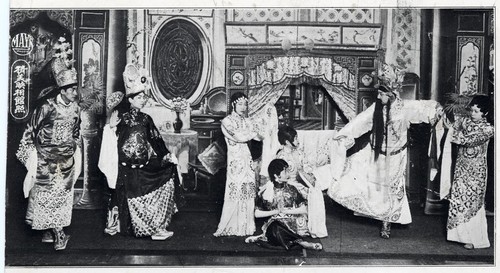 Seven actors portray a dramatic palace scene possibly at the Great Star Theatre /