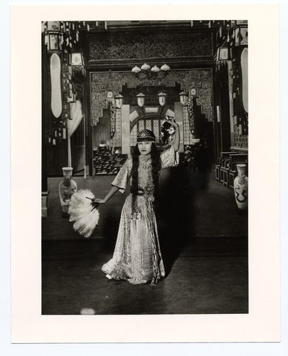 Actress in classical dan costume in dance pose holding a feather fan /