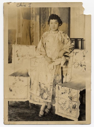 Actress in a funeral setting holds a handkerchief and a fan /