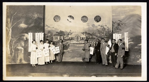 Members of the Kuomintang party gather at the Great China Theatre in front of a painted set depicting the resting place of the 72 Martyrs /