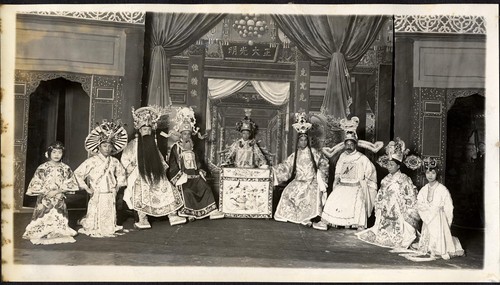 Court scene of judgment, two men and two women kneeling await sentence of seated official, staged at the Great Star Theatre /