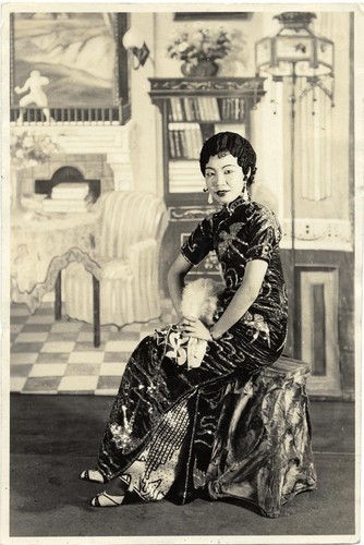 Seated actress dressed in sequinned cheongsam /