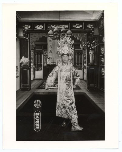 Actor as gallant warrior in long embroidered civilian gown and ornate headdress /