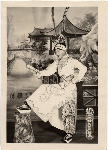 Actress in the role of a warrior/scholar reads a book, possibly at the Great Star Theatre /