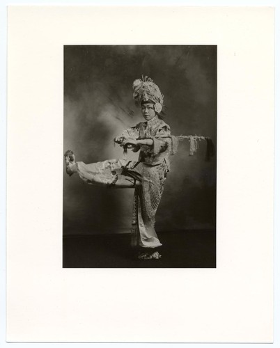 Studio portrait of actor holding a riding crop on imaginary horseback /