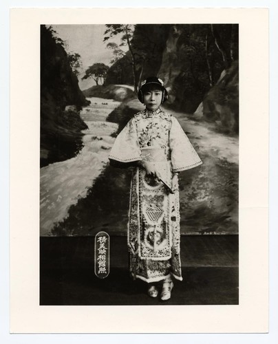 Actress with an "ear muff" hairdo in 1910-20s stage costume with wide sleeves /