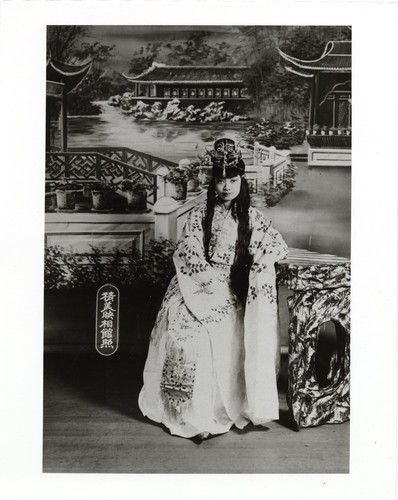 Actress in ornate classical costume with long water sleeves and classical style harido seated at table /