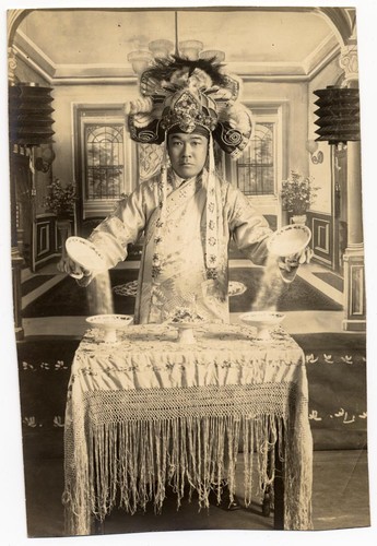 Actor stands before a table with food dishes /