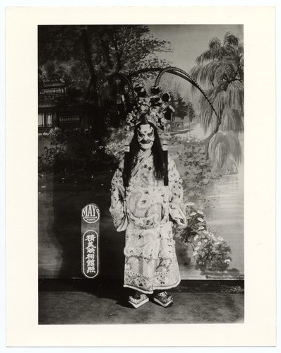 Standing warrior with pheasant plume headress and by make-up an evil character /