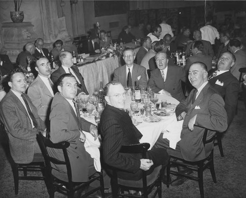 Photograph of a group of men at a circular dining table