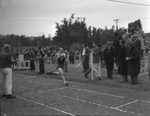 [Fullerton track team member crossing the finish line]