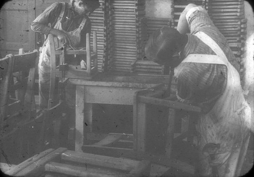 [Two campus carpenters constructing chairs]