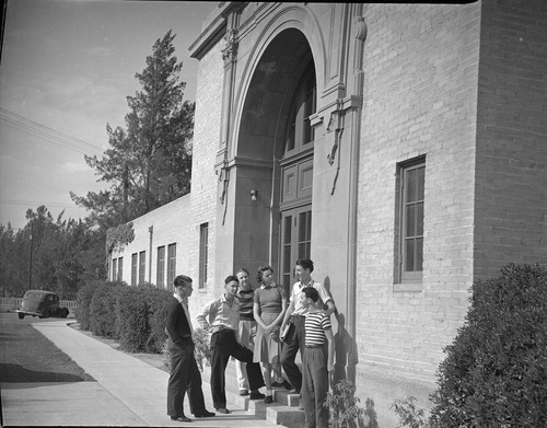 [Students gathered in front of school building]