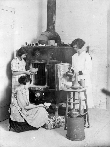 [Students in pottery class at kiln]