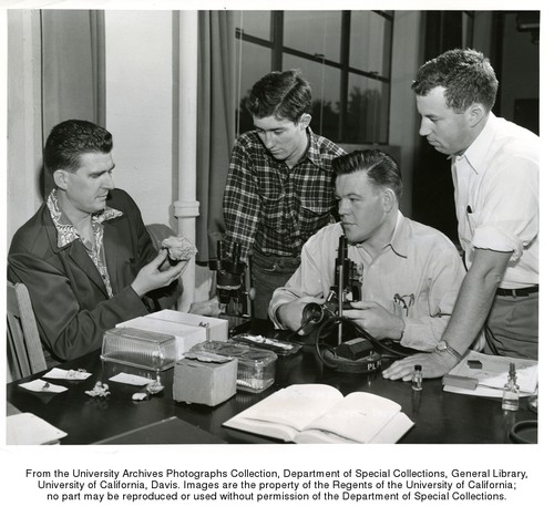 Nyland, George (left), Assistant Professor of Plant Pathology in the University of California College of Agriculture, shows a portion of a common tree mushroom to three of his students, l-r, George P. Bonacich, Lloyd V. Edgington, and Noel F. Sommer. The students are members of a class in mycology, the study of fungi. Microscopes are used to examine the spore formation in the fungi