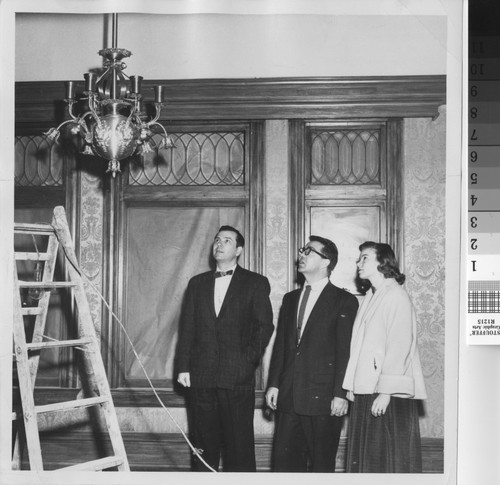 Library staff looking at chandelier