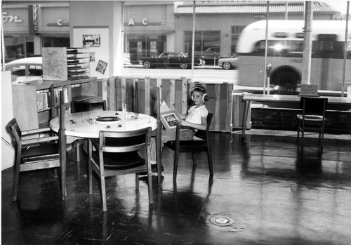 Photograph of young boy with earphones at the Inglewood Public Library, North La Brea Ave. location