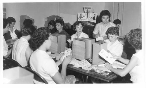 Group of Lady Volunteers Stuffing Envelopes with Christmas Seals