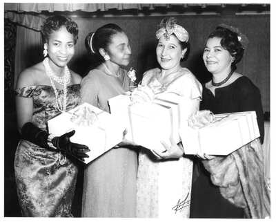 Four women holding presents at the Rhododendron Club fashion show at Slim Jenkins